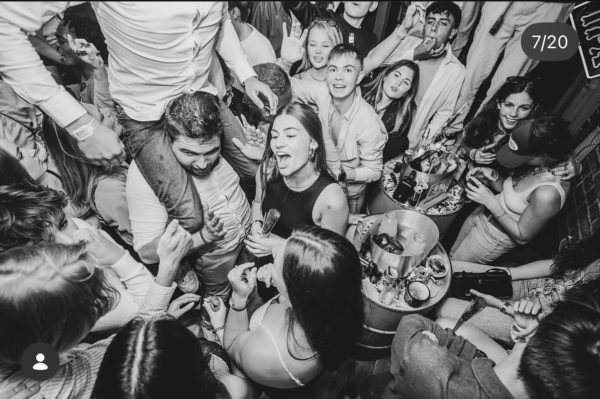La foule réunie dans le bar en noir et blanc